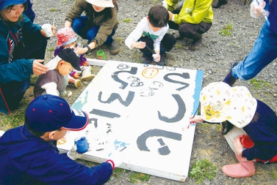 写真：看板に絵を描く子どもたち