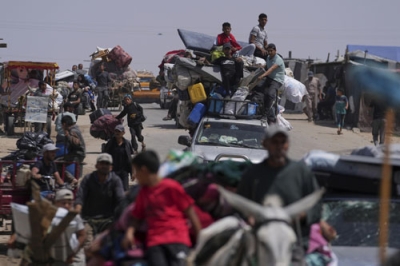 写真：１９日、イスラエル軍の攻撃が続くガザ南部ハンユニスから逃れる避難民（ＡＰ＝共同）