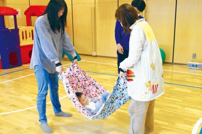 写真：手作りハンモック遊びを楽しむ親子