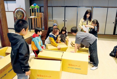 写真：非常時用の段ボールベッドを組み立てる子どもたち