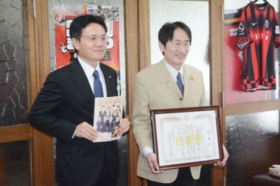 写真：人権啓発図書を寄贈した有富会長（右）と大塩町長