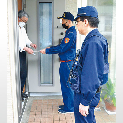 写真：母恋地区の住民に防火指導を行う市消防団員（中央）と室蘭署員