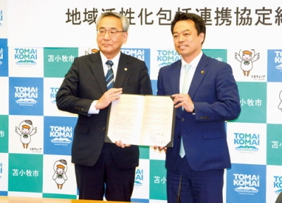 写真：協定書に署名した金澤市長（右）と齋藤社長