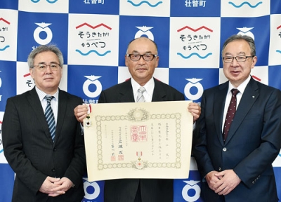 写真：田鍋町長に旭日双光章受章を報告した、元壮瞥町議の横山さん（中央）