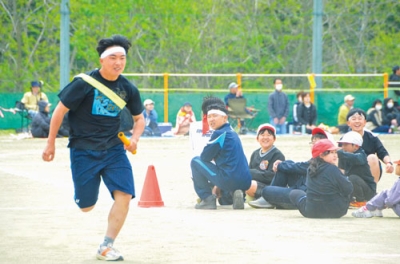 写真：異学年で参加したリレーで力走する生徒