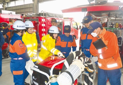 写真：小型ポンプの点検を行う消防職員と団員ら
