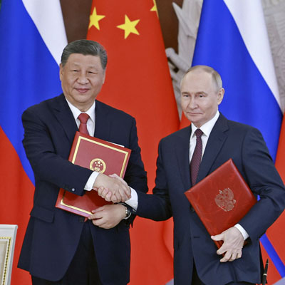 写真：共同声明に署名し握手する中国の習近平国家主席（左）とロシアのプーチン大統領＝８日、モスクワ（新華社＝共同）