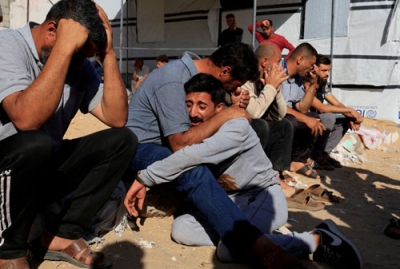 写真：イスラエル軍による攻撃の犠牲者の葬儀で悲しむパレスチナ人ら＝２５日、ガザ南部ハンユニス（ロイター＝共同）