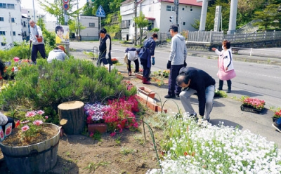 写真：花植え作業に取り組む泉町会の会員ら（提供写真）