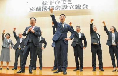 写真：出席者とガンバローコールをする松下氏（中央）