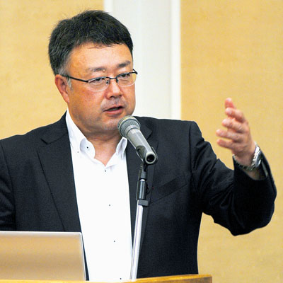 写真：電材重機の歴史を紹介する上村社長