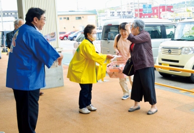 写真：買い物客に啓発物を配布する小笠原市長（左）ら
