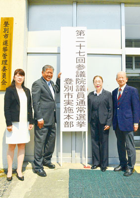 写真：看板を設置した和田委員長（左から２人目）ら市選管役員