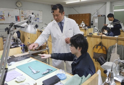 写真：近江時計眼鏡宝飾専門学校で学生を指導する染矢泰輔さん＝大津市