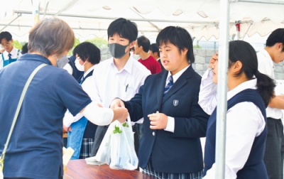 写真：藍の苗を介して絆を育む生徒と来場者