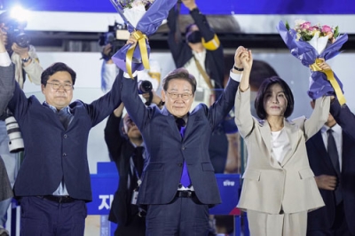 写真：韓国大統領選で当選を確実にし、支持者の前で花束を掲げる「共に民主党」の李在明前代表（中央）＝４日未明、ソウルの国会前（共同）