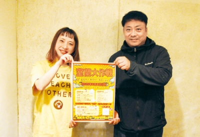 写真：ポスターを手にイベントをアピールする細川委員長（右）とメンバーの羽澤さん