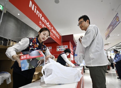 写真：「ニンテンドースイッチ２」を受け取る男性（右）＝５日午前、大阪市中央区