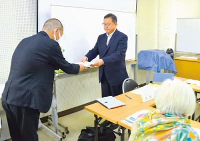写真：鈴木館長からアーニス移転の是非について諮問を受ける松田会長