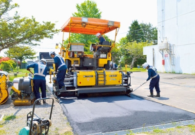 写真：重機などを使い、補修作業を行う菱中建設の社員ら