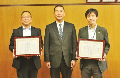 写真：寄贈への感謝状を手にする森田代表取締役（左）と山上支店長（右）