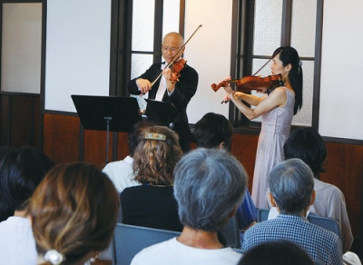 写真：美しいバイオリンの音色を届ける齋藤さん夫妻