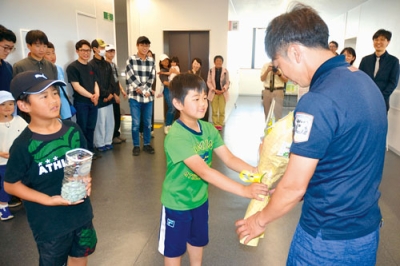 写真：市消防本部で職員に花束を贈る子どもたち