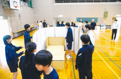 写真：段ボールベッド作りに取り組む生徒たち