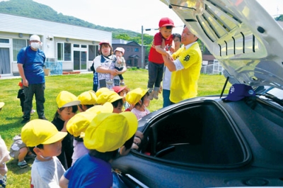 写真：テスラ社のＥＶを見学する園児たち