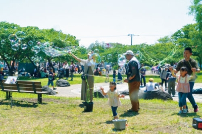 写真：会場でシャボン玉飛ばし体験を楽しむ家族連れ