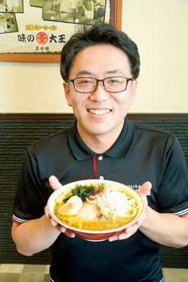写真：「一郎カレーラーメン」を手にＰＲする中江代表取締役