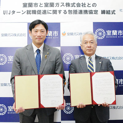 写真：協定を締結した青山市長（左）と末長社長
