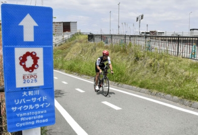 写真：大阪・関西万博会場への案内板が設置されている「大和川リバーサイドサイクルライン」＝６月、堺市