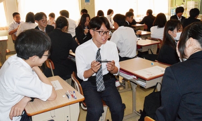 写真：自分の持っている筆記用具の特長を紹介する生徒たち
