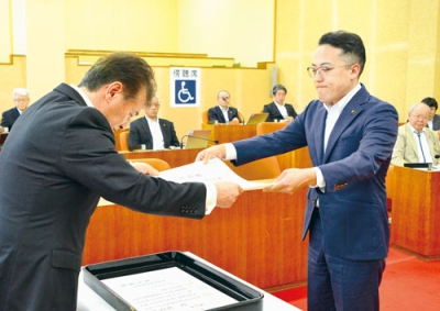 写真：千田議長から表彰状を受け取る辻議員（右）