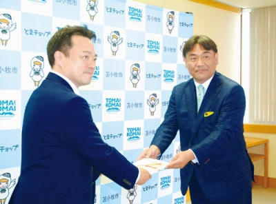 写真：金澤市長（左）に目録を手渡す金丸社長