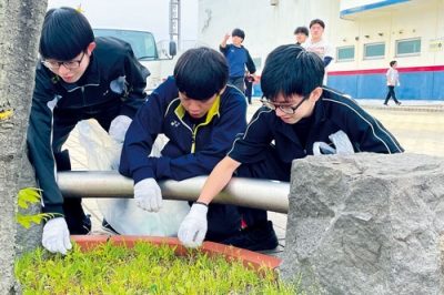 写真：ごみを拾い集める新入社員たち