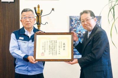 写真：功労者感謝状を受け取った大同電設の織田社長（左）