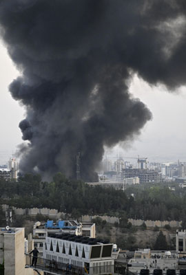 写真：イスラエル軍による攻撃を受け、黒煙を上げるイラン国営テレビ本部＝１６日、テヘラン（共同）