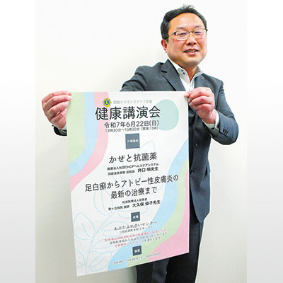写真：ポスターを手に健康講演会をＰＲする目良会長