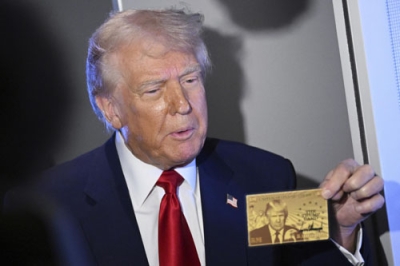 写真：「トランプカード」を示すトランプ米大統領＝４月、大統領専用機内（ＡＰ＝共同）