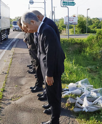 写真：事故のあった現場に献花し、黙とうする日本クリーンファームの社員ら＝１８日午前、八雲町
