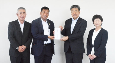 写真：鈴木副会頭（右から２人目）から義援金を受け取ったウーさん（同３人目）と鈴木さん（左端）