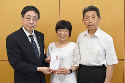 写真：髙木事務局長に寄付金を手渡す（右から）斉藤会長、松山さん
