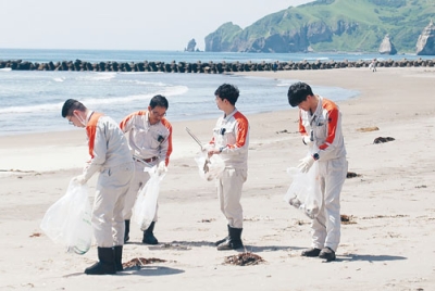 写真：イタンキ浜でごみ拾いに汗を流す幌清の社員ら