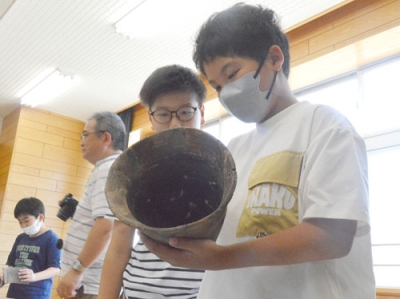 写真：縄文土器に触れる若草小児童