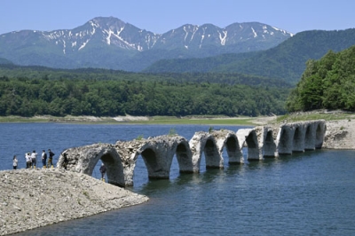 写真：糠平湖に沈み始めた旧国鉄士幌線のアーチ橋「タウシュベツ川橋梁」＝１９日午前、上士幌町