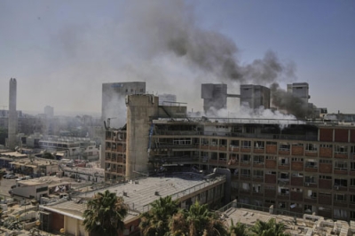 写真：イスラエル南部ベエルシェバで、イランのミサイルが着弾し煙を上げる病院＝１９日（ＡＰ＝共同）