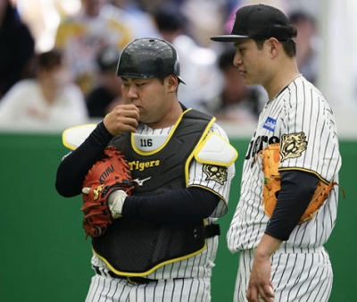 写真：春季キャンプで大竹（右）と話す阪神のブルペン捕手を務める寺前湧真さん＝２月、宜野座