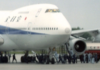 写真：１９９５年６月、ハイジャックされた全日空機にはしごをかけ、機内に突入する捜査員ら＝函館空港